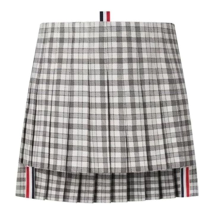 Thom Browne low-rise mini pleated skirt in grey and white gingham check with layered hem and red, white, and blue grosgrain trim - packshot