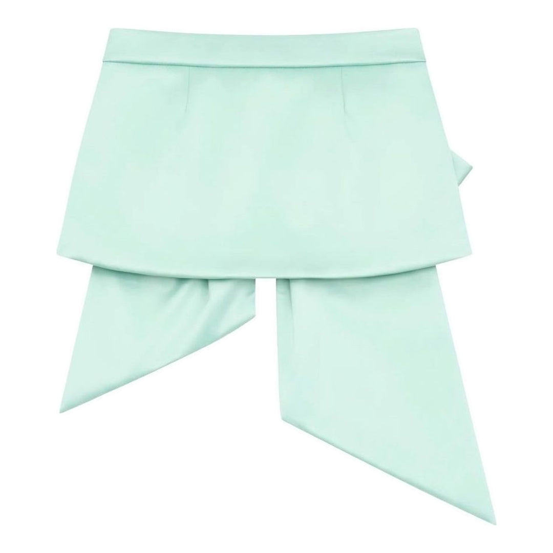 Vaquera mint green satin mini skirt with an oversized pleated bow overlay and long trailing tails, shown flat against a white background - packshot