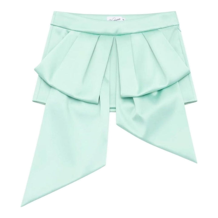 Vaquera mint green satin mini skirt with an oversized pleated bow overlay and long trailing tails, shown flat against a white background - packshot