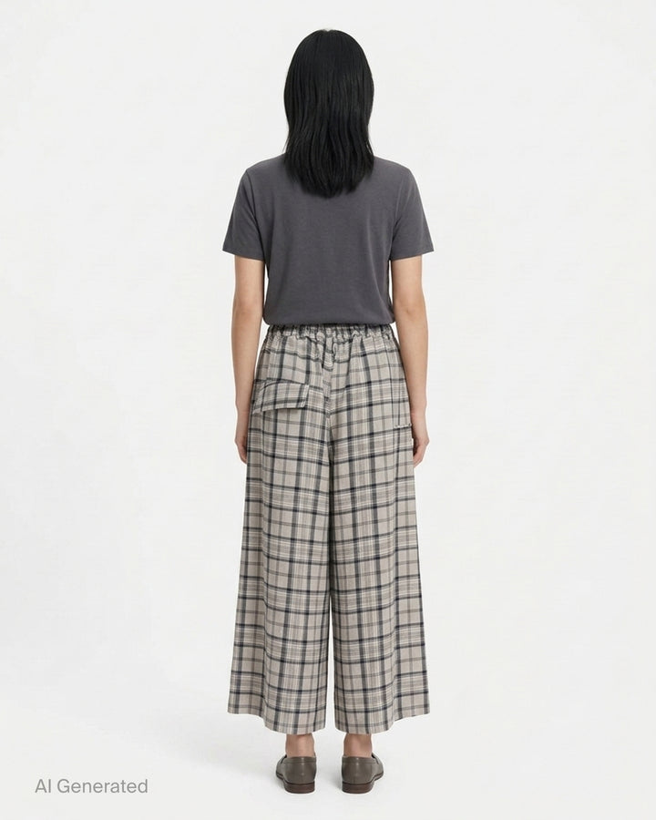 Y's wide-leg pants in a grey and navy plaid crinkled fabric with a gathered elasticated waist and draped asymmetric side panel, shown from the front - back